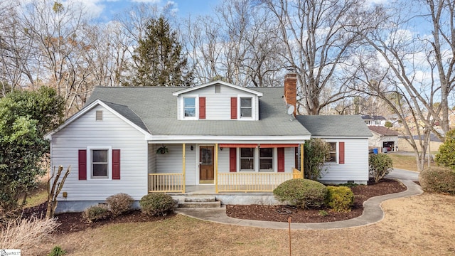 cape cod home featuring a porch and a front lawn