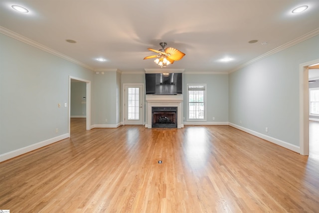 unfurnished living room featuring ceiling fan, ornamental molding, and light hardwood / wood-style flooring