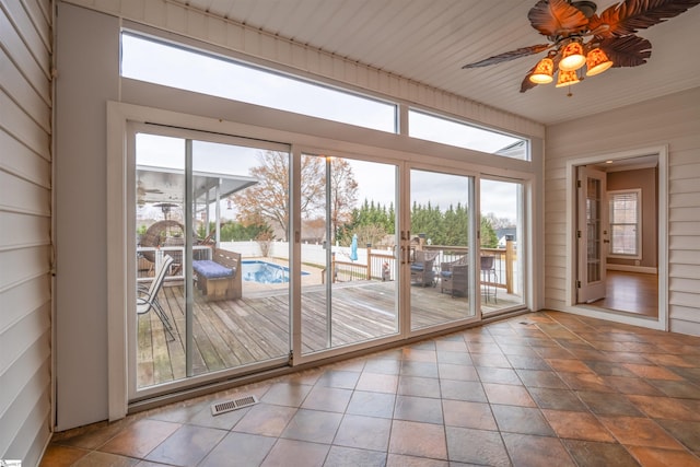 doorway to outside featuring ceiling fan, wooden ceiling, and wooden walls