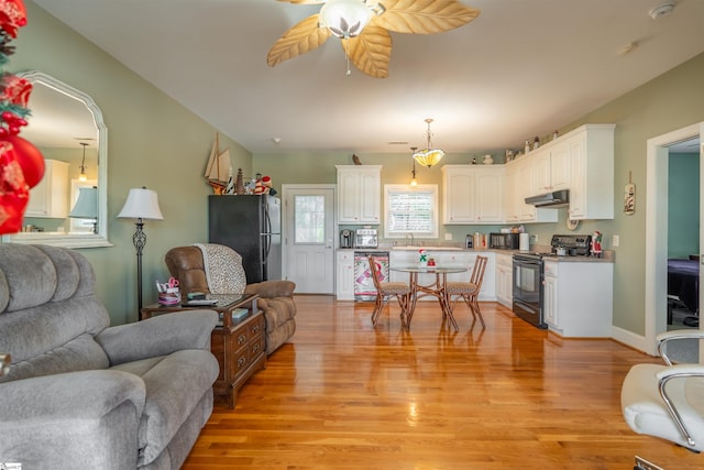 living room featuring ceiling fan, sink, and light hardwood / wood-style flooring