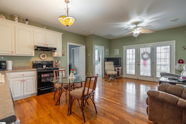 kitchen featuring light hardwood / wood-style flooring, electric range, ceiling fan, decorative light fixtures, and white cabinetry