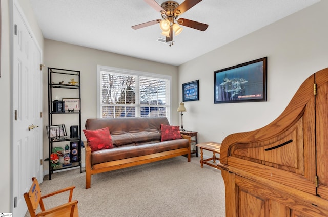 living area with carpet and ceiling fan