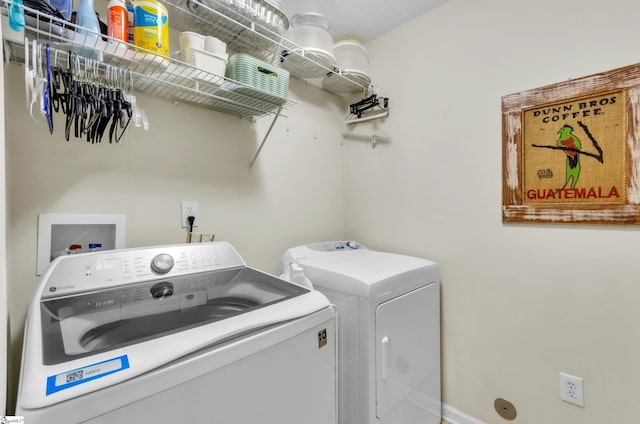 washroom with a textured ceiling and washer and clothes dryer