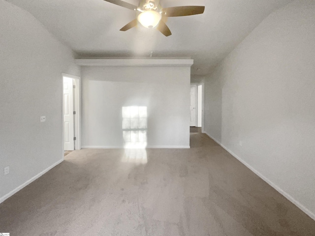 carpeted spare room featuring vaulted ceiling and ceiling fan