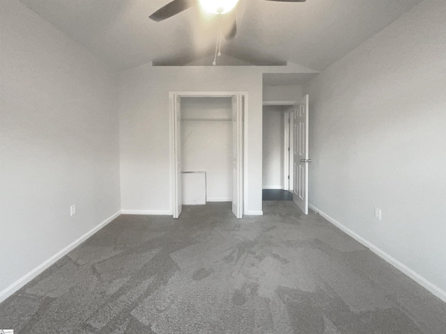 unfurnished bedroom with ceiling fan, dark carpet, and lofted ceiling