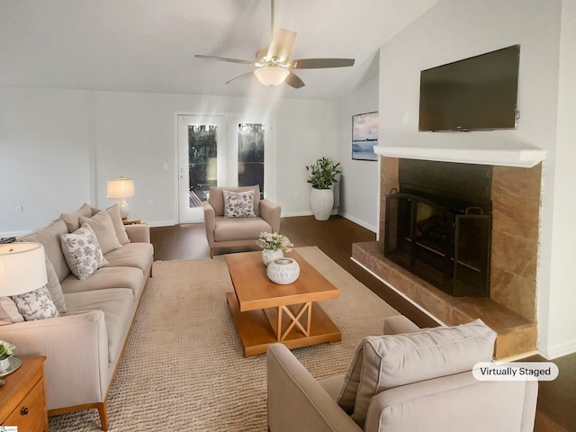 living room with ceiling fan, a fireplace, and vaulted ceiling