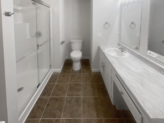 bathroom featuring tile patterned flooring, vanity, toilet, and an enclosed shower