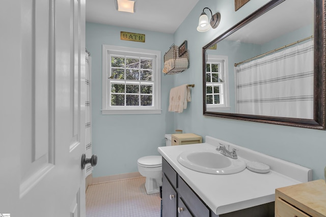 bathroom with tile patterned flooring, vanity, and toilet