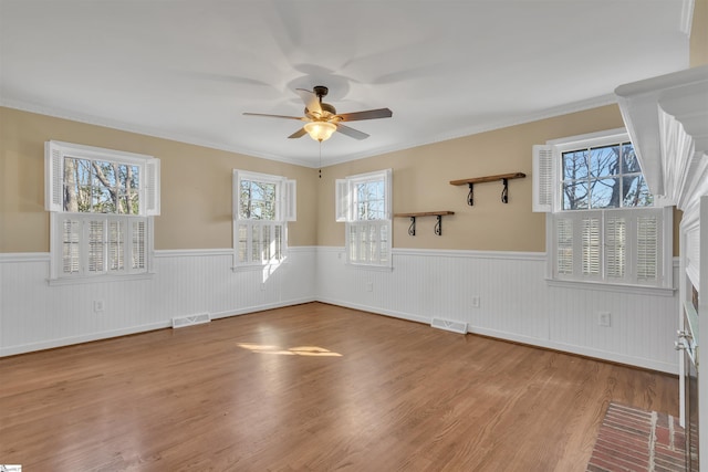 spare room featuring ceiling fan, a healthy amount of sunlight, and light hardwood / wood-style floors