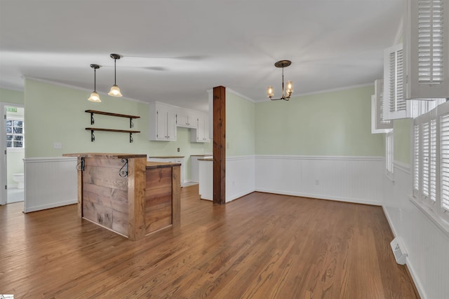 kitchen with dark hardwood / wood-style flooring, white cabinetry, and ornamental molding