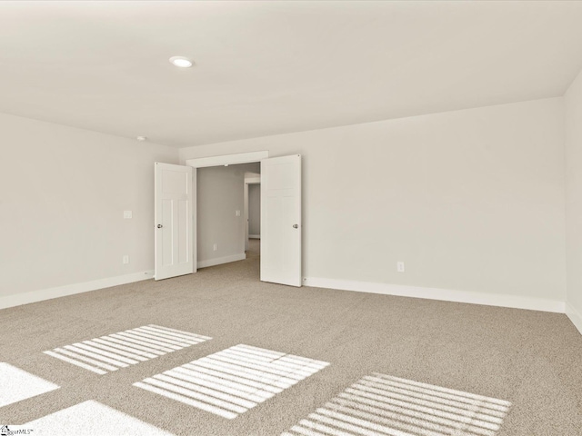 unfurnished room featuring light colored carpet