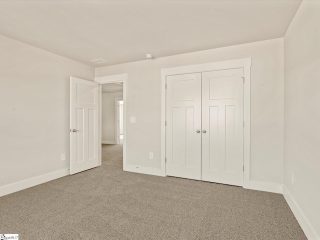 unfurnished bedroom with a closet and carpet flooring