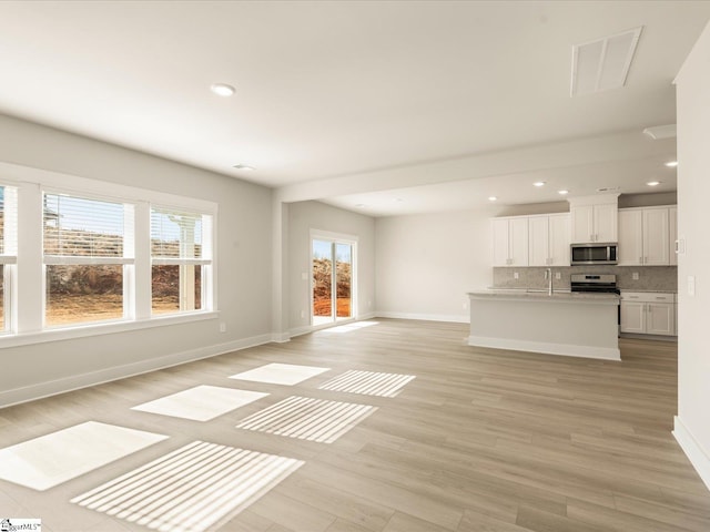 unfurnished living room featuring light hardwood / wood-style floors and sink