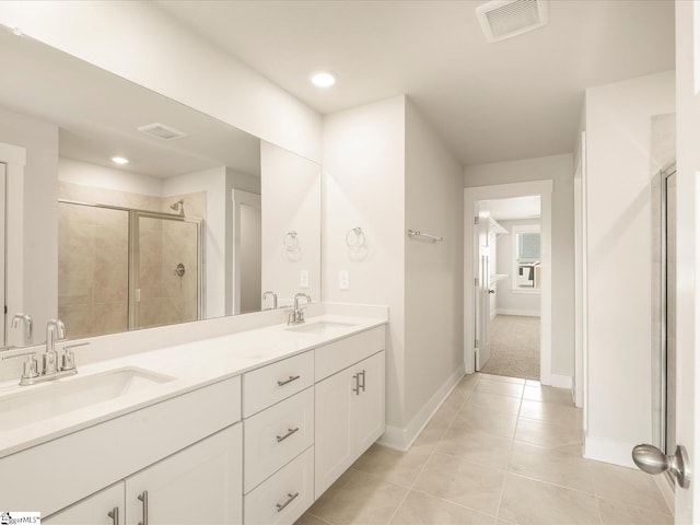 bathroom featuring tile patterned flooring, an enclosed shower, and vanity