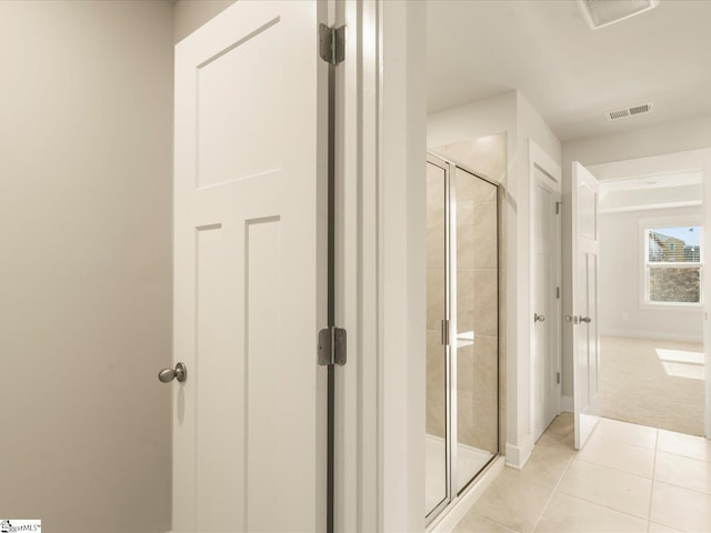 bathroom featuring an enclosed shower and tile patterned flooring