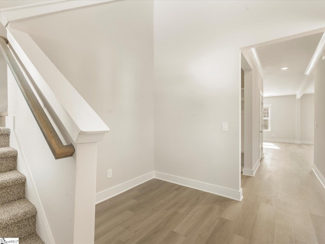 hallway featuring ornamental molding and hardwood / wood-style floors