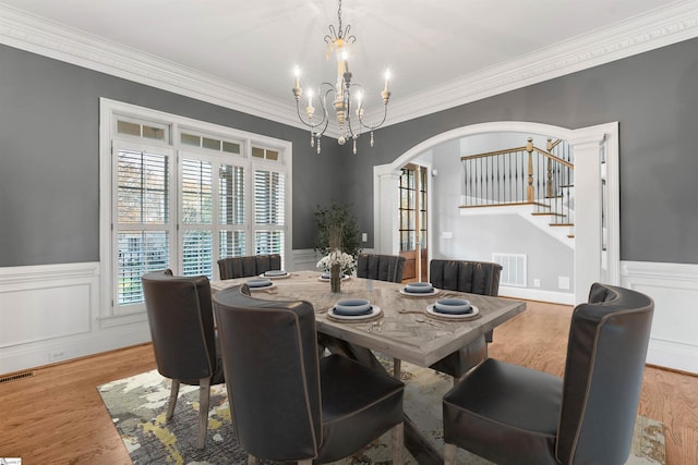 dining space with a chandelier, light hardwood / wood-style flooring, and crown molding