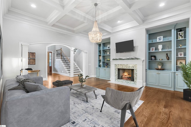 living room featuring beam ceiling, a fireplace, wood-type flooring, and coffered ceiling