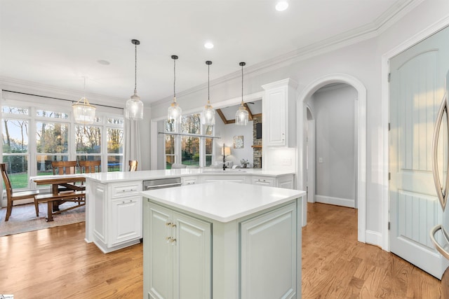 kitchen featuring kitchen peninsula, a center island, pendant lighting, and light wood-type flooring