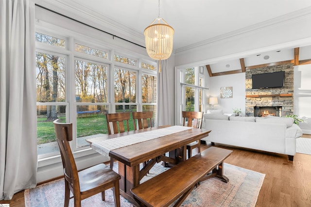 sunroom / solarium with lofted ceiling with beams, a fireplace, and a chandelier