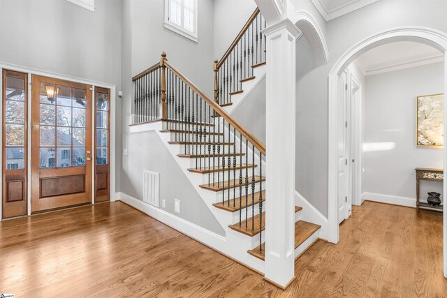 entrance foyer featuring plenty of natural light, light wood-type flooring, and ornamental molding