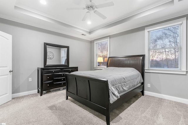 bedroom with carpet flooring, a raised ceiling, ceiling fan, and ornamental molding