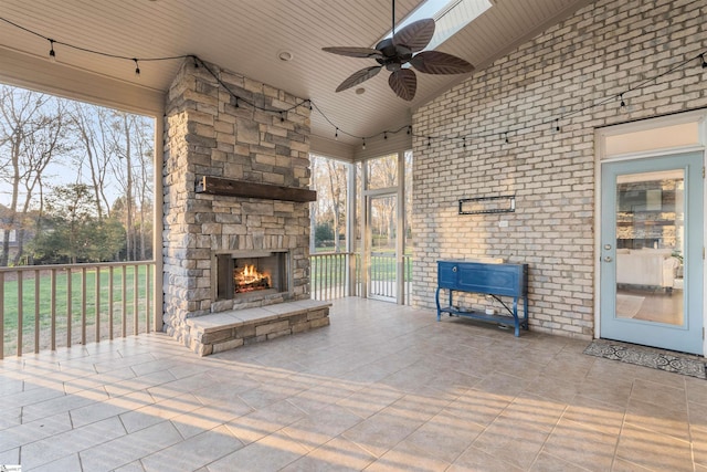 view of patio with ceiling fan and an outdoor stone fireplace