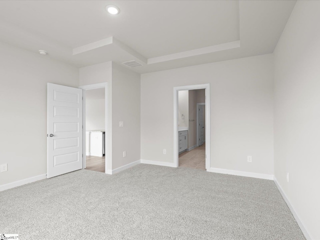 unfurnished bedroom with light colored carpet and ensuite bath