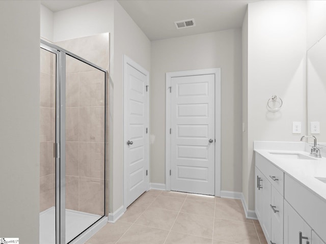 bathroom featuring tile patterned flooring, vanity, and a shower with shower door