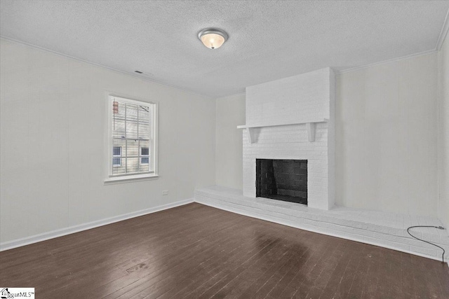 unfurnished living room featuring a textured ceiling, ornamental molding, dark hardwood / wood-style floors, and a brick fireplace