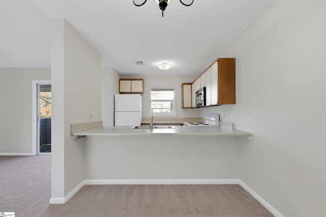 kitchen with light carpet, stove, white fridge, and sink