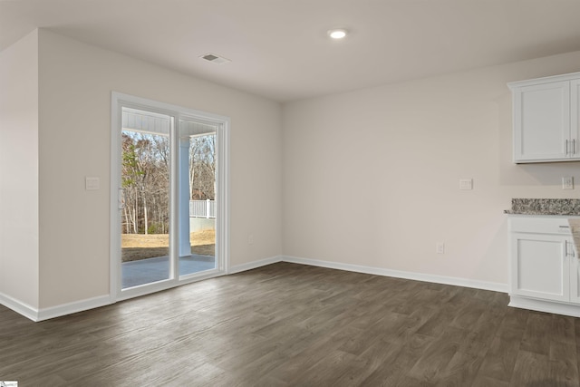 unfurnished dining area with dark wood-type flooring