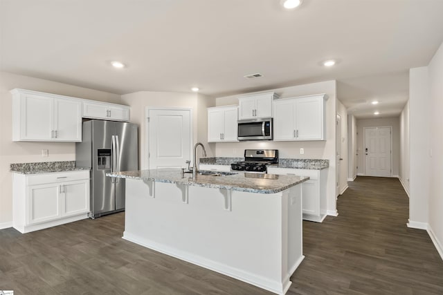 kitchen with white cabinetry, sink, dark hardwood / wood-style floors, an island with sink, and appliances with stainless steel finishes