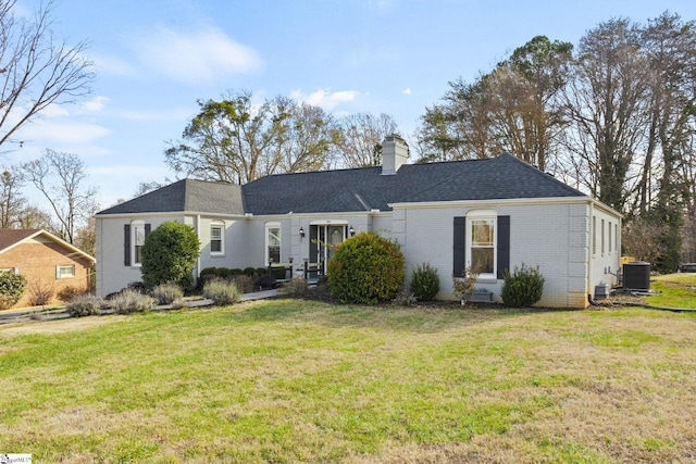 view of front of home with central AC and a front lawn