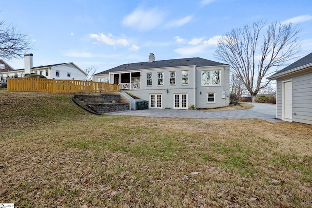 back of house featuring french doors, a patio, and a lawn