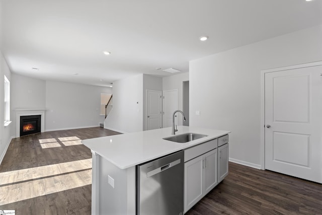 kitchen with a sink, dishwasher, dark wood finished floors, and light countertops