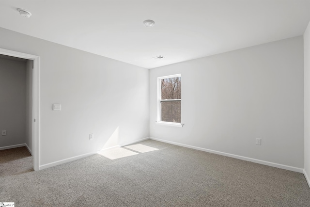 unfurnished room featuring visible vents, baseboards, and carpet