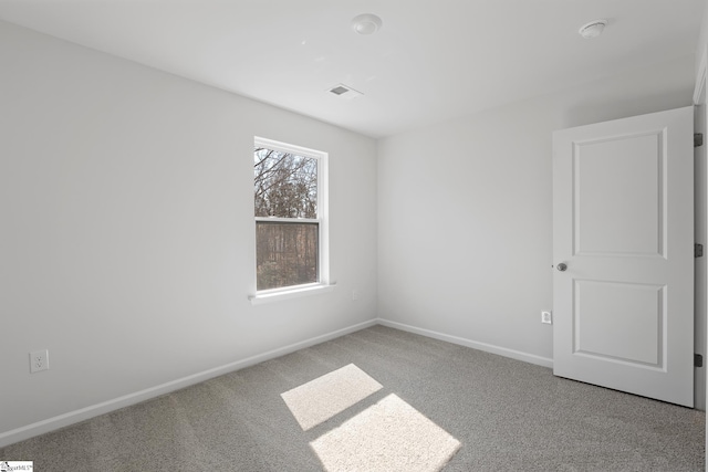 carpeted empty room featuring visible vents and baseboards