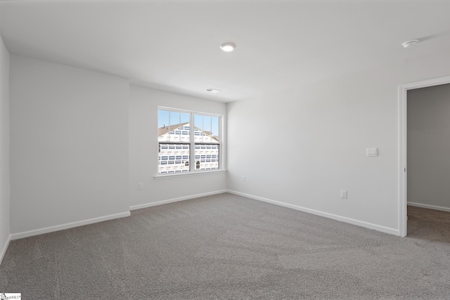 unfurnished room with baseboards and carpet