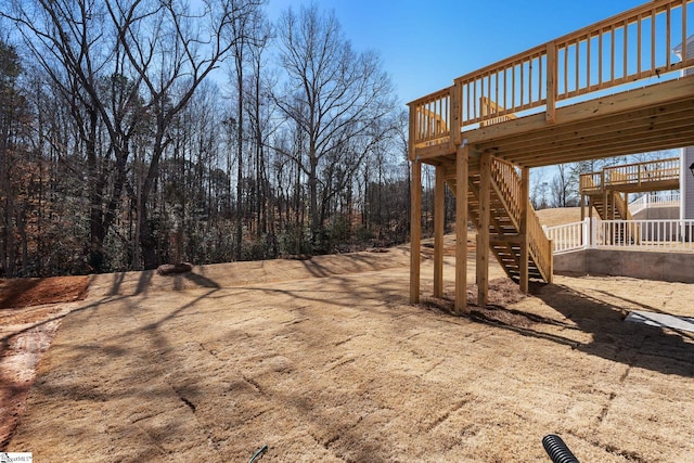 view of yard with stairs and a deck