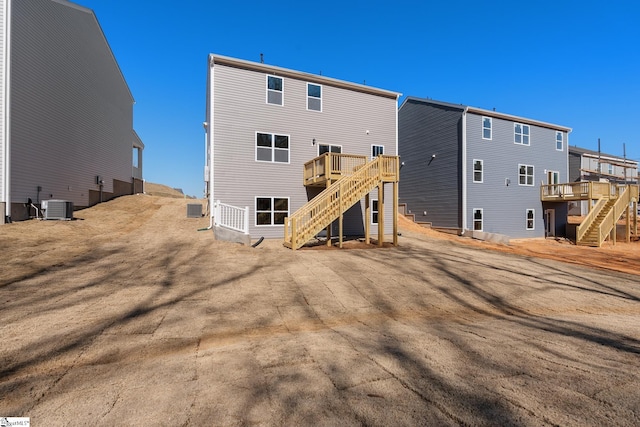 back of house featuring a wooden deck, stairs, and central AC