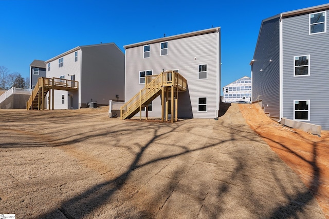 rear view of house with stairway, cooling unit, and a wooden deck