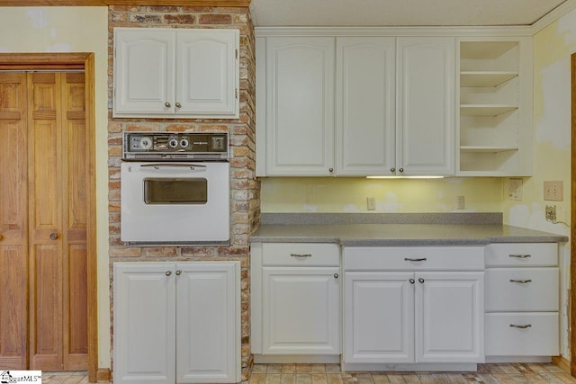 kitchen featuring white oven and white cabinets