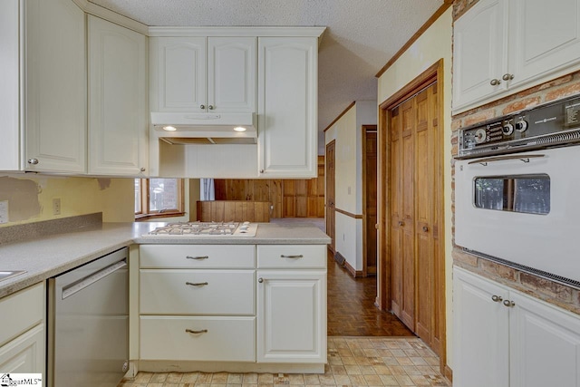 kitchen featuring white cabinets, a textured ceiling, and white appliances