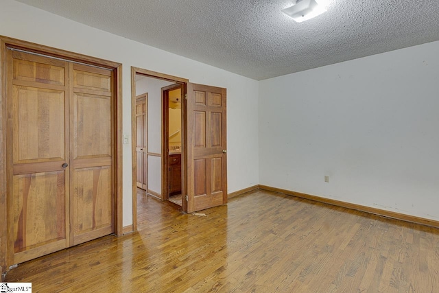 unfurnished bedroom with a textured ceiling and light wood-type flooring