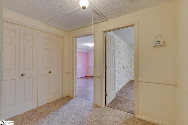 hallway featuring a textured ceiling and carpet floors