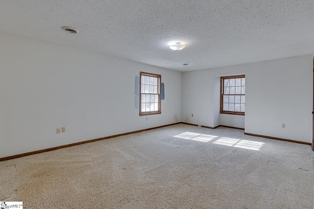 carpeted spare room with a textured ceiling