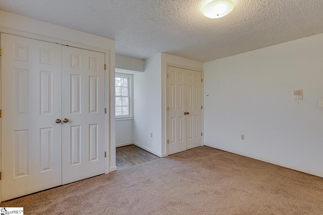 unfurnished bedroom featuring light carpet and a textured ceiling