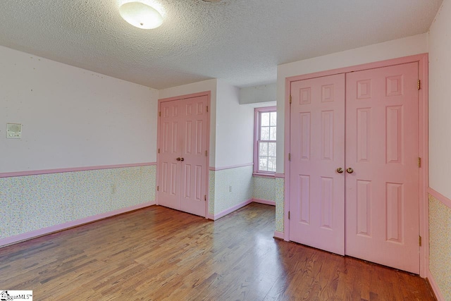 unfurnished bedroom featuring a textured ceiling and hardwood / wood-style flooring