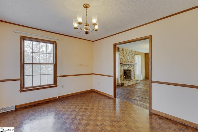 unfurnished room featuring dark parquet flooring, a stone fireplace, crown molding, a textured ceiling, and a chandelier